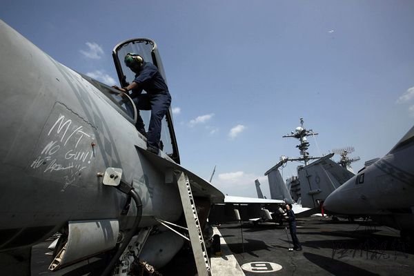 资料图片:一名机师正在检修航母上的“大黄蜂”舰载战斗机。“华盛顿”号航母上共装载有超过70架舰载飞机。