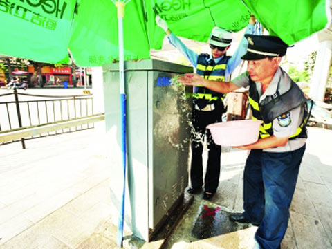 武汉天太热红绿灯停摆罢工 交警为红绿灯控制箱泼水降温