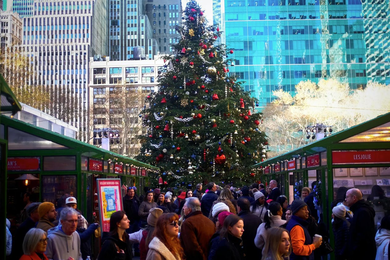 2023年12月15日，美国纽约市曼哈顿市中心的一棵大圣诞树下，假日购物者挤满了季节性的布莱恩特公园冬季村。