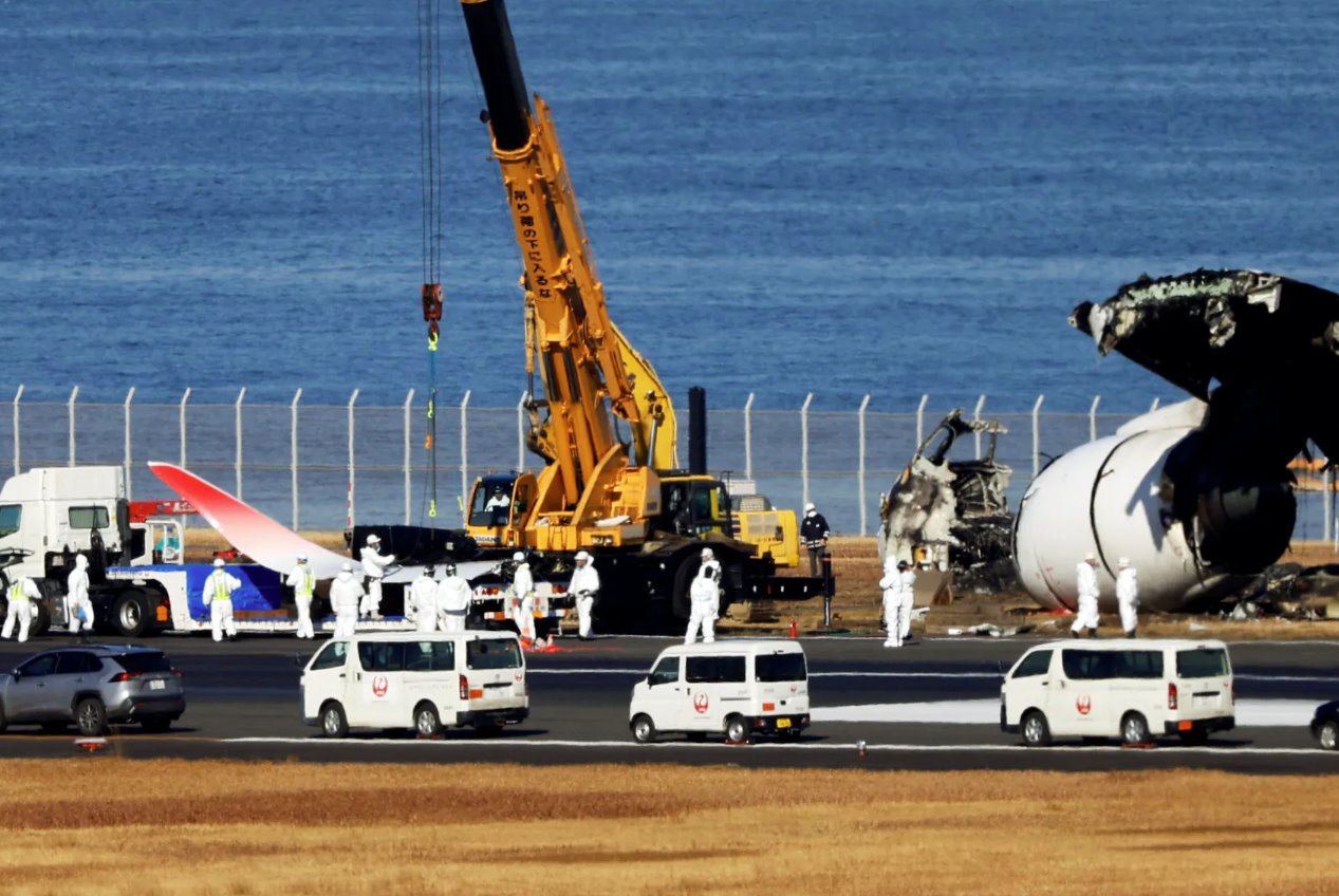 2024年1月5日，日本东京羽田国际机场，日本航空(JAL)一架空客A350飞机与日本海岸警卫队飞机相撞，官员们正在清除被烧毁的残骸。