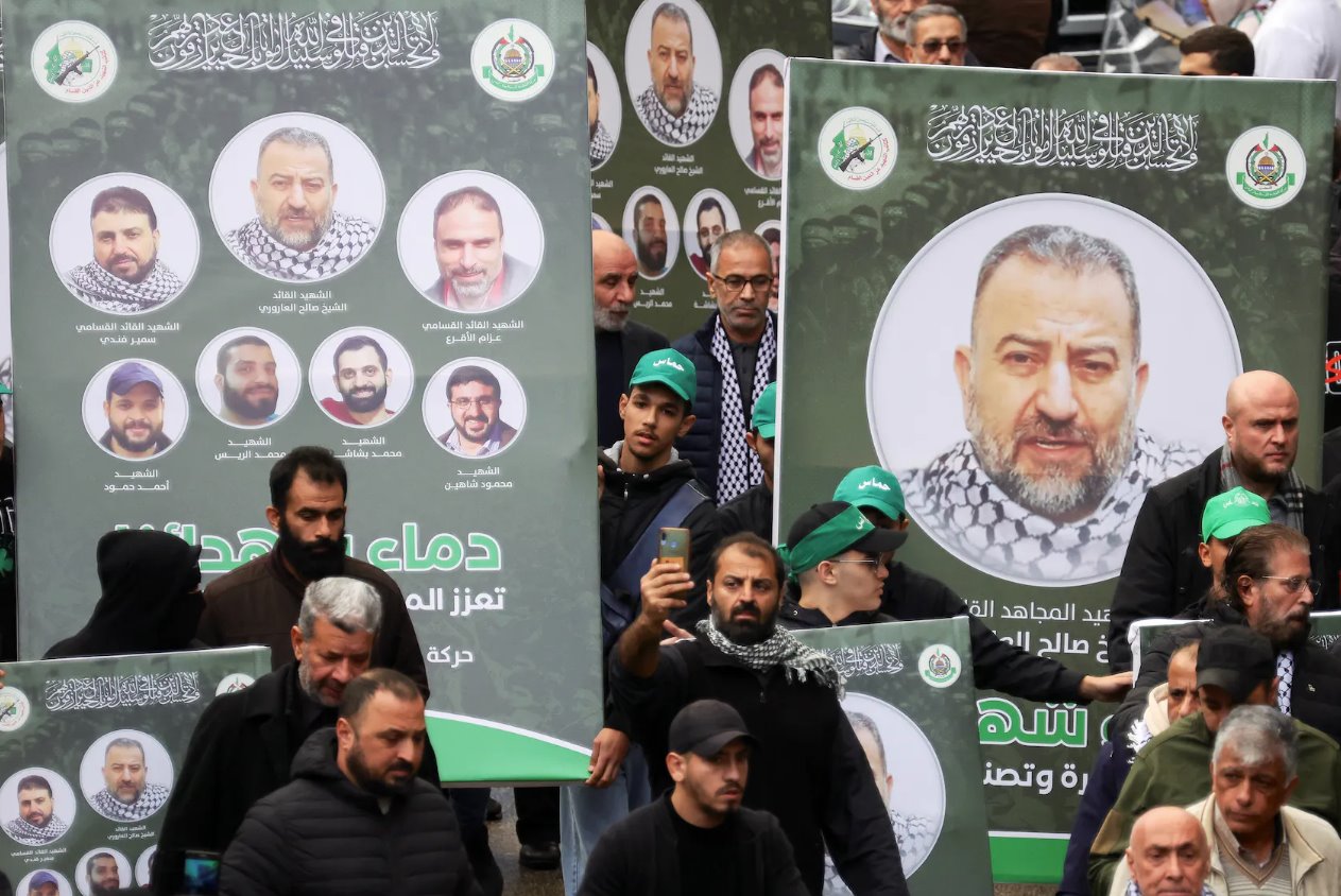 2024年1月4日，黎巴嫩贝鲁特，哀悼者聚集在他的葬礼上，人们举着印有哈马斯副领导人萨利赫·阿鲁里(Salehal-Arouri)照片的标语牌。