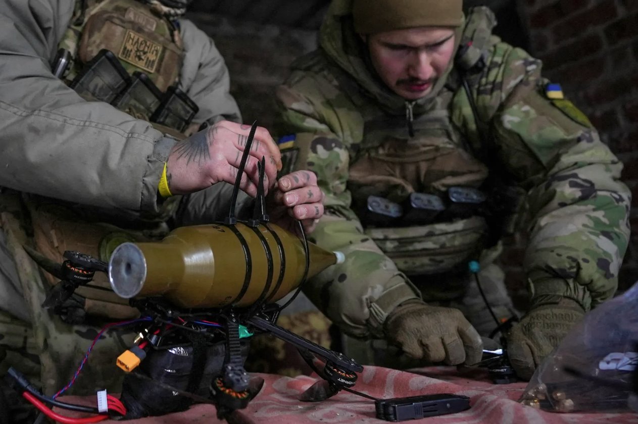 在俄罗斯对乌克兰顿涅茨克地区的攻击期间，第24独立机械化旅拉罗格无人机中队的乌克兰军人在霍尔利夫卡镇附近的一个位置将RPG-7榴弹发射器的炮弹安装到第一人称视角(FPV)无人机上2024年1月17日。