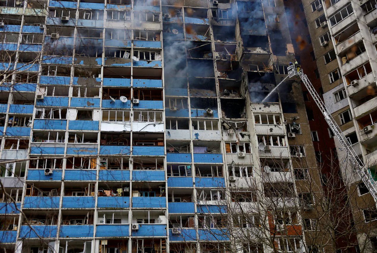 2024年2月7日，乌克兰基辅，消防员在俄罗斯袭击乌克兰期间因俄罗斯导弹袭击而受损的建筑物现场工作。