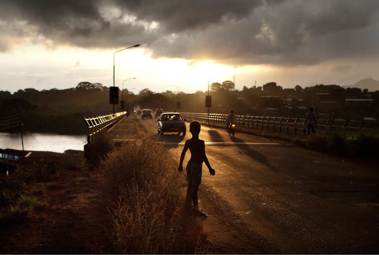 2012年11月21日黎明时分，一名男孩站在塞拉利昂弗里敦的一条路上。