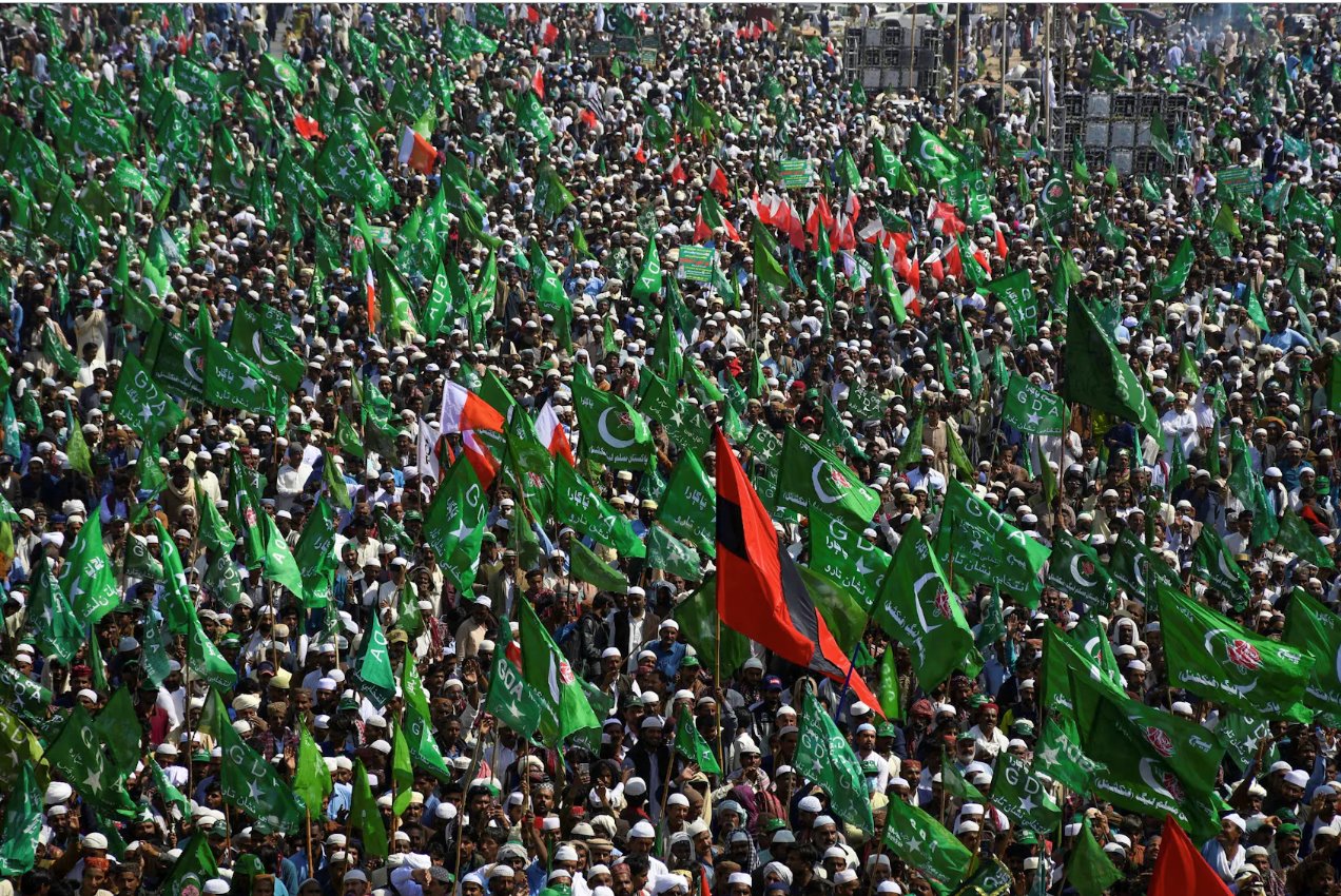 联盟大民主联盟（GDA）的支持者举着旗帜聚集议，反对他们所谓的选举操纵行为，巴基斯坦贾姆肖罗，2024年2月16日。