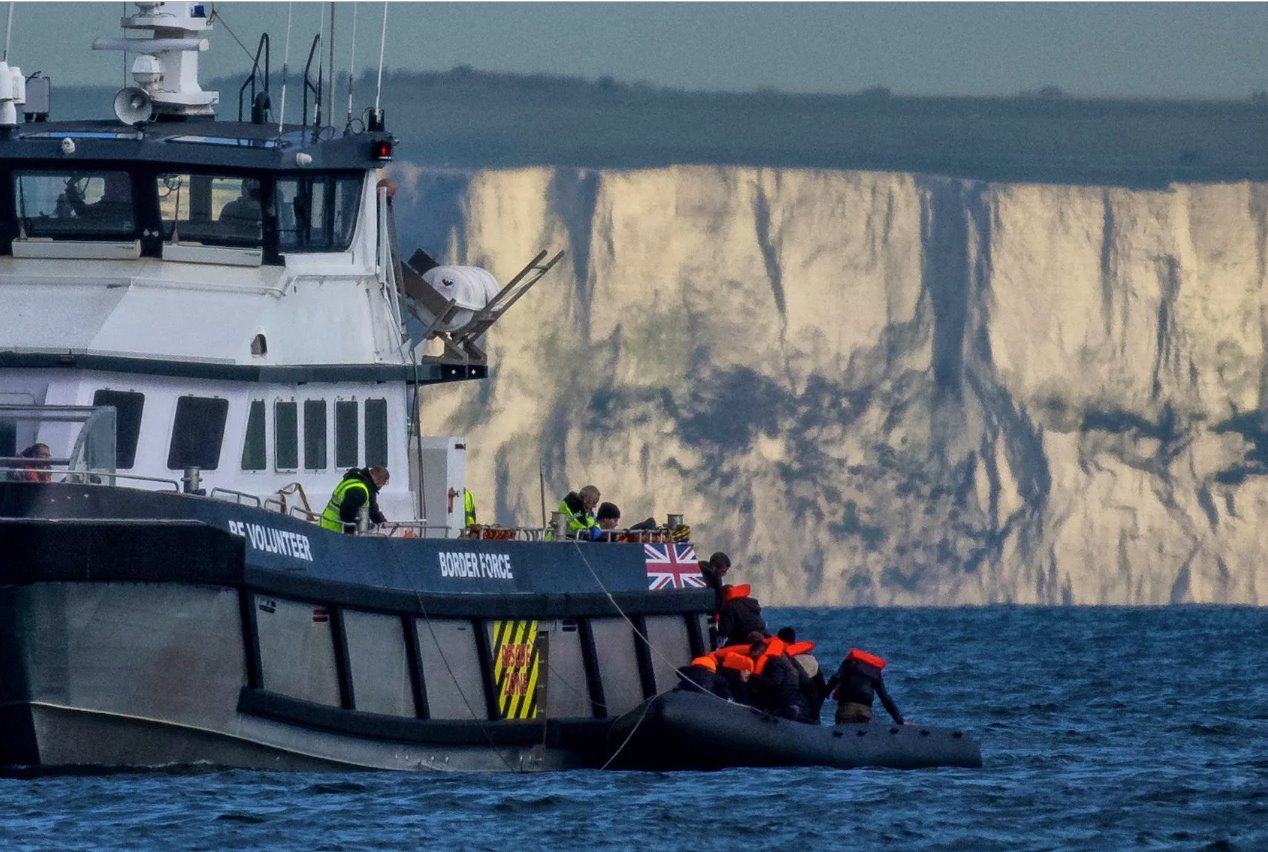 2024年5月4日，一艘英国边境部队船只在英国英吉利海峡多佛的白色悬崖前接载一艘载有移民的充气小艇。
