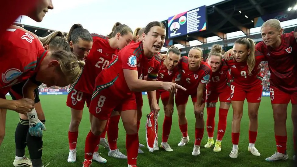 威尔士女队在球场上聚在一起